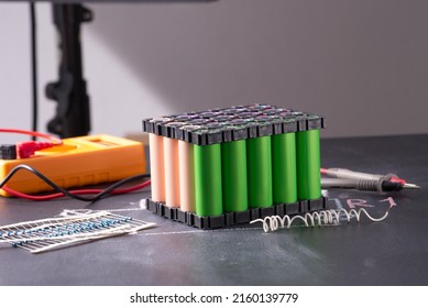 Lithium battery pack in black plastic holder on dark background.
