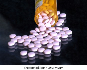 Lithium Pills Poured From A Prescription Medication Container Onto A Dark Glass Surface.