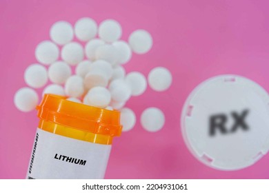 Lithium Rx Medicine Pills In Plactic Vial With Tablets. Pills Spilling   From Yellow Container On Pink Background.