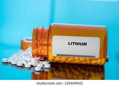 Lithium White Medical Pills And Tablets Spilling Out Of A Drug Bottle. Macro Top Down View With Copy Space.