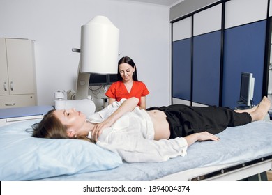 Lithotripsy for kidney and ureteral stones in modern center. Young woman doctor, using ultrasound scan to determine the stone position before the lithotripsy for her female patient