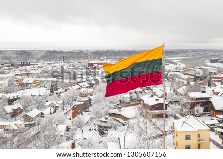 Lithuanian flag in the wind. Kaunas city in the background. Drone aerial view.