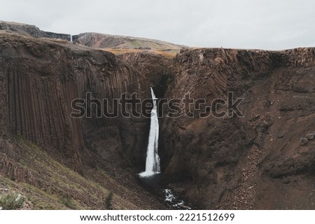 Litlanesfoss, waterfall framed by massive, hexagonal basalt columns, reached by an uphill hiking path, very close to Hengifoss