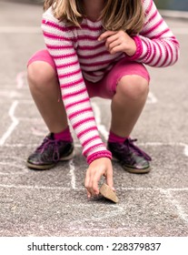 Litlle girl playing on the hopscotch