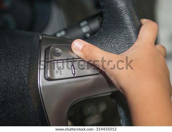 Litte\
girl hand push hand free button on steering\
wheel