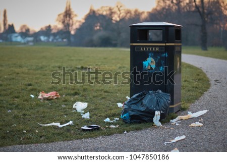 The litter bin in public park and litter around .