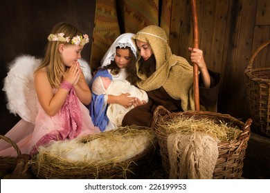 Little 7 Year Old Angel Visiting A Nativity Scene Reenacted With A Doll