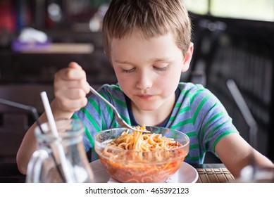 Little 7 Years Old Boy Child Eating Spaghetti Bolognese In The Restaurant