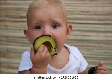 Little Adorable Baby Eating Avocado. Vitamin And Healthy Food For Small Children. 