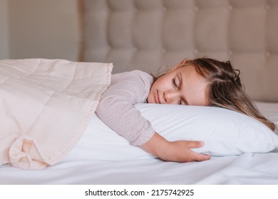 Little Adorable Blonde Girl In Cotton Pajamas Closed Eyes Lying In Bed Sleeping On Comfortable Pillow Under Blanket, Good Night Sweet Dreams Health Care, Real Life Moment Concept