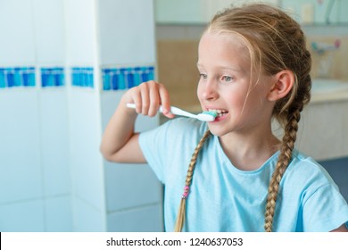 Little adorable girl brushes teeth in the bathroom. Perfect snow-white smile of little girl - Powered by Shutterstock