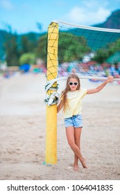 Little Adorable Girl Playing Voleyball On Beach With Ball.