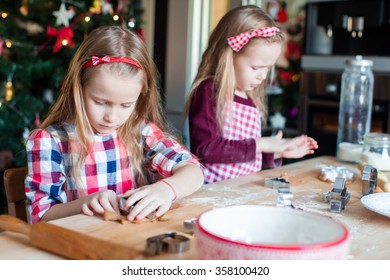 Little Adorable Girls Baking Gingerbread House On Christmas Eve