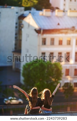Little adorable girls on rooftop enjoying with view of old european city