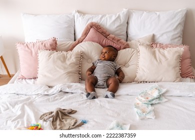 Little African American Baby Boy Wearing Jumpsuit Lying On Bed At Home