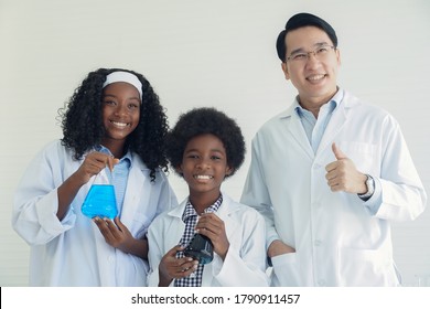 Little African Kids Learning Chemistry And Doing A Chemical Science Experiment In A Laboratory In School Clever Black Boy And Girl Holding Liquid In Experimental Flask With Teacher On White Background