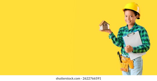 Little African-American architect with house model on yellow background with space for text