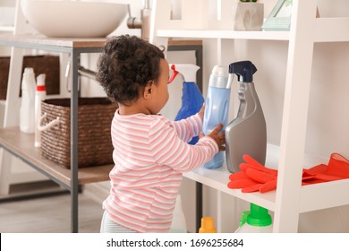 Little African-American Baby Playing With Washing Liquids At Home. Child In Danger