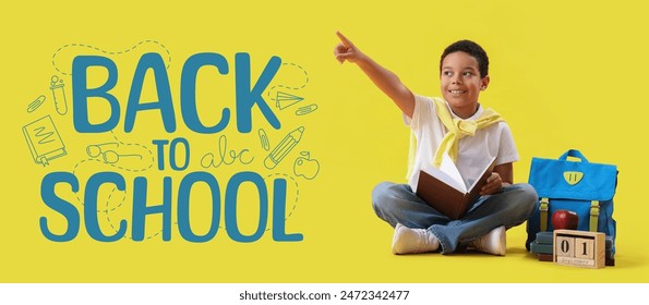 Little African-American boy with book, backpack, calendar and apple on yellow background. Back to school - Powered by Shutterstock