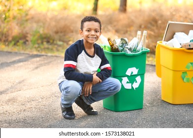 Little African-American boy collecting trash outdoors. Concept of recycling - Powered by Shutterstock