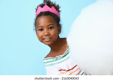 Little African-American girl with cotton candy on blue background - Powered by Shutterstock