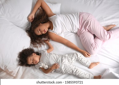 Little African-American Girl With Mother Sleeping In Bed At Night