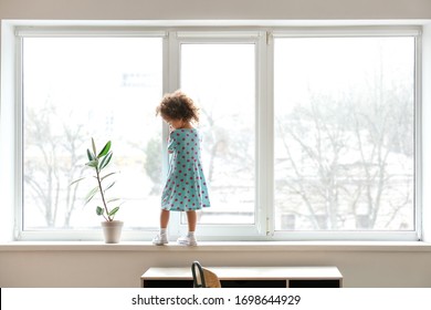 Little African-American Girl Near Window. Child In Danger