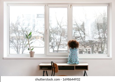 Little African-American Girl Near Window. Child In Danger