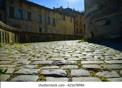 Little Alley With Cobblestones And Old Stone Buildings In Uzès, In The South Of France.