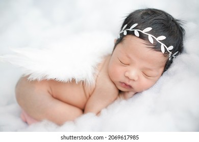 little angel baby with angel wings sleeping on white clouds.