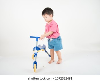 Little Asain Baby Toddler Ride A Tricycle Bike On White Background