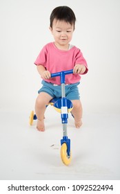 Little Asain Baby Toddler Ride A Tricycle Bike On White Background