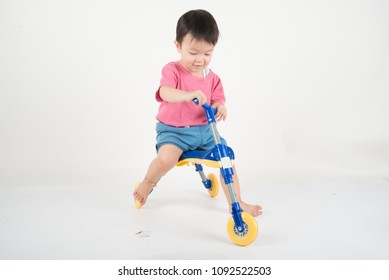 Little Asain Baby Toddler Ride A Tricycle Bike On White Background