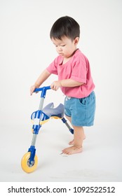 Little Asain Baby Toddler Ride A Tricycle Bike On White Background