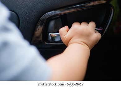 Little Asian 18 Months / 1 Year Old Baby Boy Child Holding On To The Door Handle Inside Of The Car, Kid Try To Open The Car Door, Child Safety Concept / Shallow Dof / Selective Focus