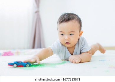 Little Asian Baby Boy Is Reach Out Hand Toy Car.Concepts Of Learning Development Of Child Movements And Catching.