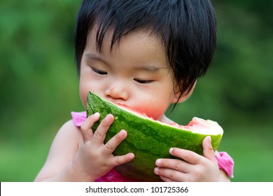 Little Asian Baby Eating Watermelon In Park