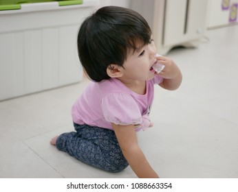 Little Asian Baby Girl, 13 Months Old, Putting / Eating A Piece Of Straw Plastic Package Picked From The Floor - Baby's Choking Hazard