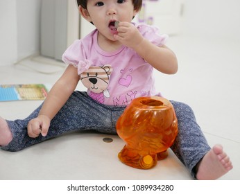 Little Asian Baby Girl, 13 Months Old, Putting / Eating A Coin Picked From The Piggy Bank - Baby's Choking Hazard