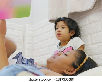 Little Asian Baby Girl, 3 Years Old, Enjoys Listening To Her Mother Reading A Bedtime Story Tale From A Book 