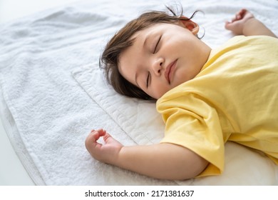 Little Asian Baby Girl Lying Down Sleeping On Bed At Home. Newborn Child Relaxing In Bed. Nursery For Young Children.