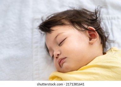 Little Asian Baby Girl Lying Down Sleeping On Bed At Home. Newborn Child Relaxing In Bed. Nursery For Young Children.