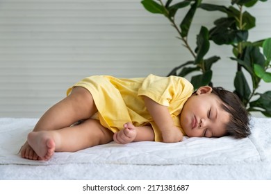 Little Asian Baby Girl Lying Down Sleeping On Bed At Home. Newborn Child Relaxing In Bed. Nursery For Young Children.