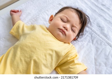 Little Asian Baby Girl Lying Down Sleeping On Bed At Home. Newborn Child Relaxing In Bed. Nursery For Young Children.