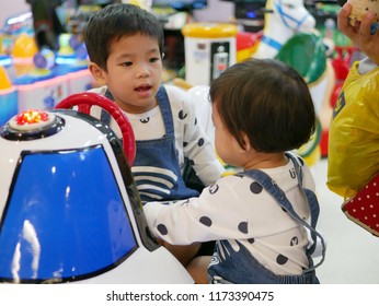 Little Asian Baby ( Left ) Refuses To Let Her Baby Sister ( Right ) Play An Arcade Game Together - Sharing Toys And Having Argument In Siblings 