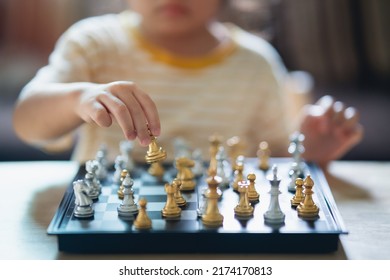 Little Asian Baby Playing Chess In The Living Room At Home.Smart Kid.fashion Children. Little Genius Child. Intelligent Game.Chessboard. Baby Activity Concept.