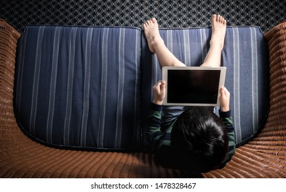 Little Asian Boy (3-6 Years Old) Left Alone With Tablet Computer Ipad. Technology Addiction Problem, Brain Impairment, Screen Time, Kids Self-absorption, Obsession, Unhealthy, Child Development.