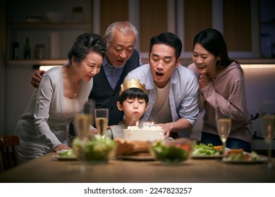 little asian boy blowing candles while three generation family celebrating her birthday at home - Powered by Shutterstock