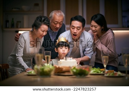 little asian boy blowing candles while three generation family celebrating her birthday at home Stock photo © 