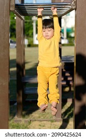 Little Asian Boy Climbing On Monkey Bar At The Outdoor Playground In The Morning